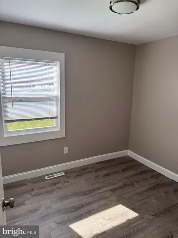 a room with a wooden floor and a window