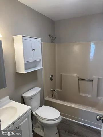 a white toilet sitting next to a bath tub