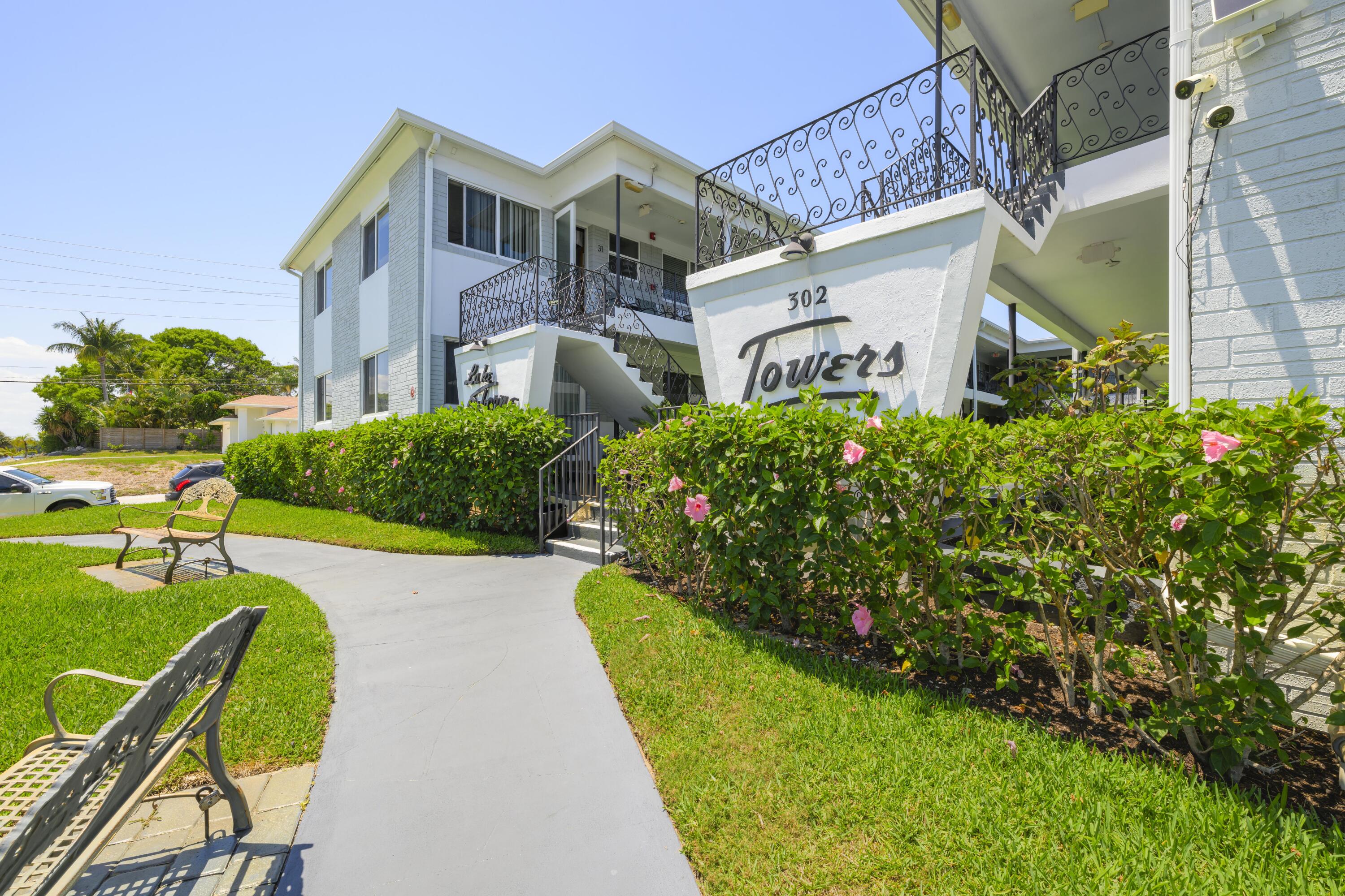 302 Lake Osborne Drive, Unit 4 Lake Worth Beach, FL 33461 - Photo 1 of 10 a front view of a house with garden