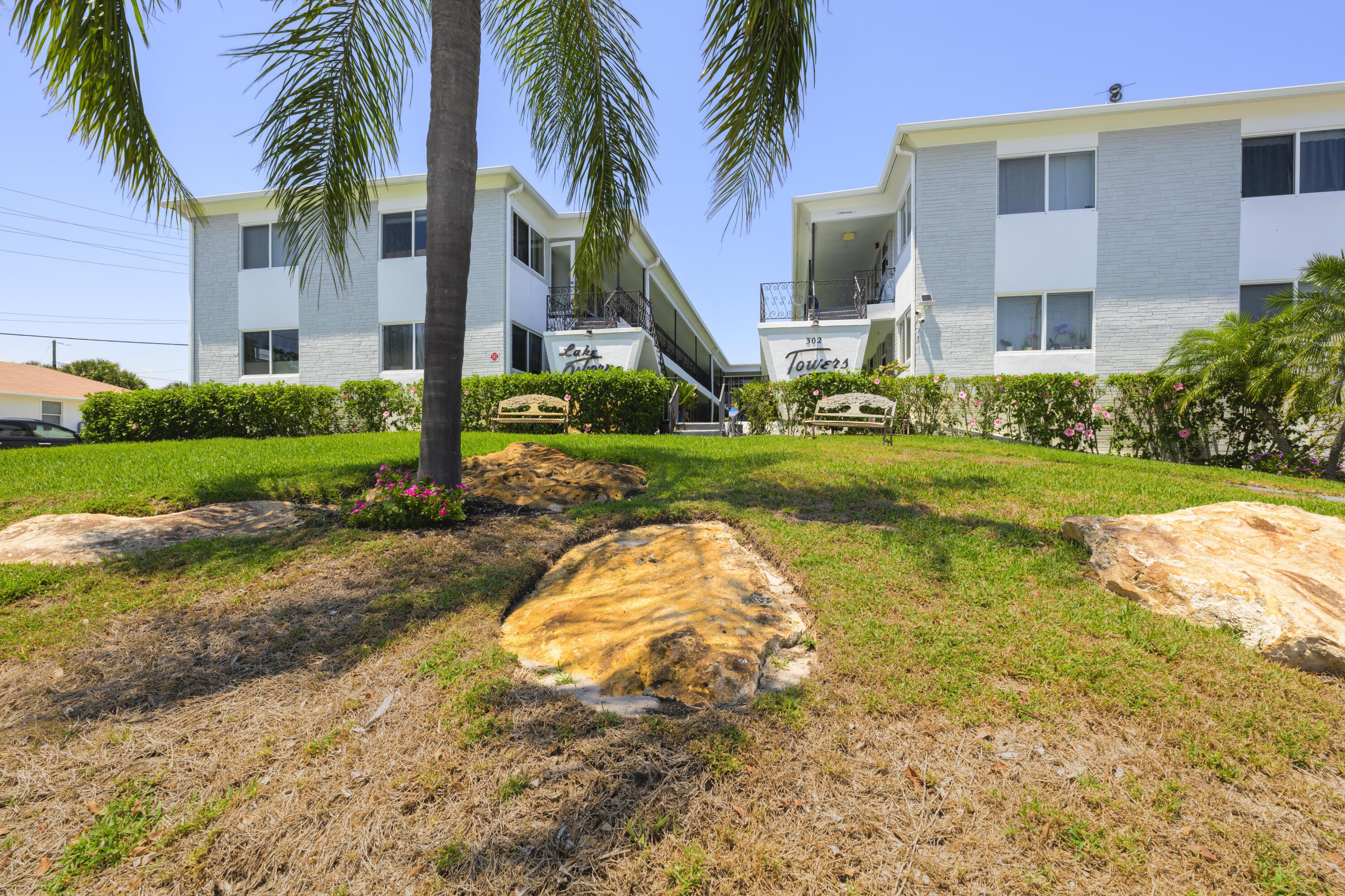 302 Lake Osborne Drive, Unit 4 Lake Worth Beach, FL 33461 - Photo 2 of 10 a view of a house with a yard and palm trees