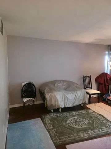 a bedroom with a bed rug and couch