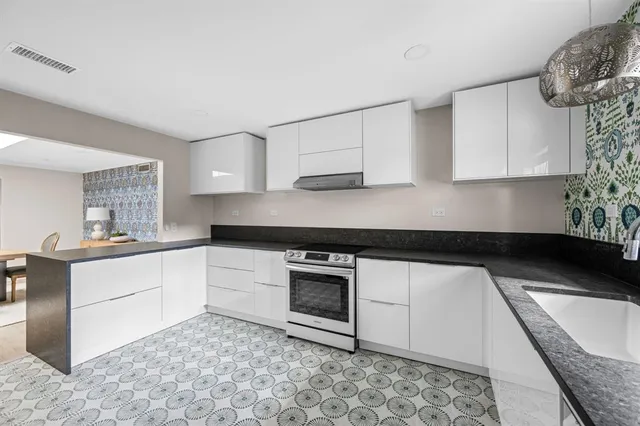 a view of a kitchen with furniture and refrigerator