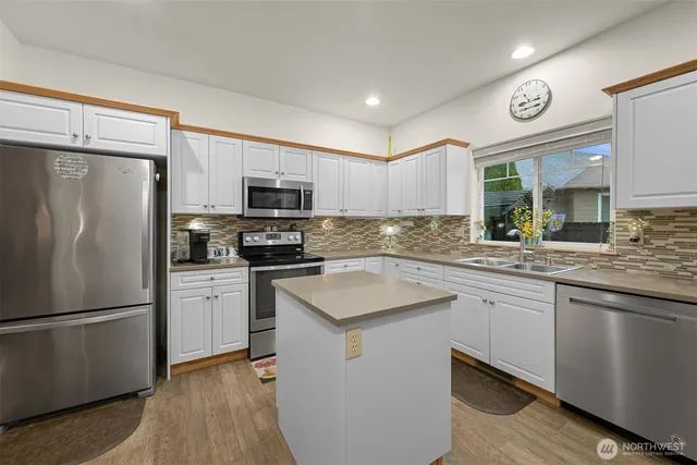 a kitchen with granite countertop stainless steel appliances a refrigerator a sink and a stove