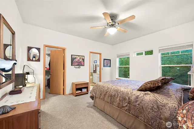 a bedroom with a bed and a large window