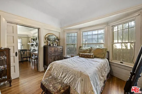 a bedroom with a bed a mirror and a large window