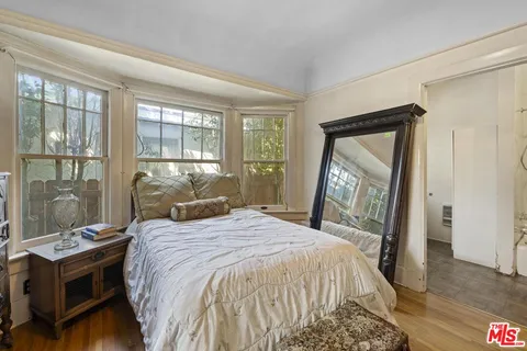 a bedroom with a bed and wooden floor