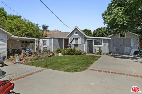 a front view of a house with cars parked