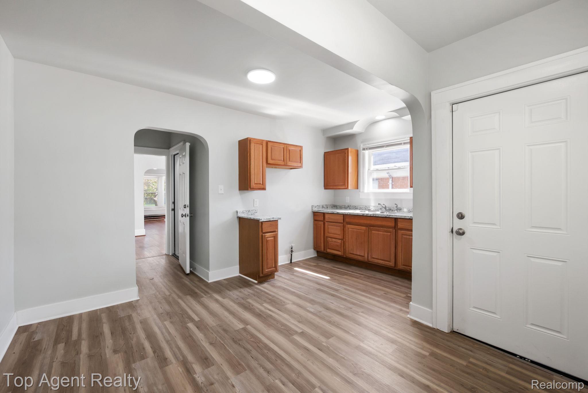 19217 Reno Street Detroit, MI 48205 - Photo 13 of 45 Wood-finish flooring throughout, arched doorway entry, recessed lighting, wood cabinetry, and a countertop with an integrated sink