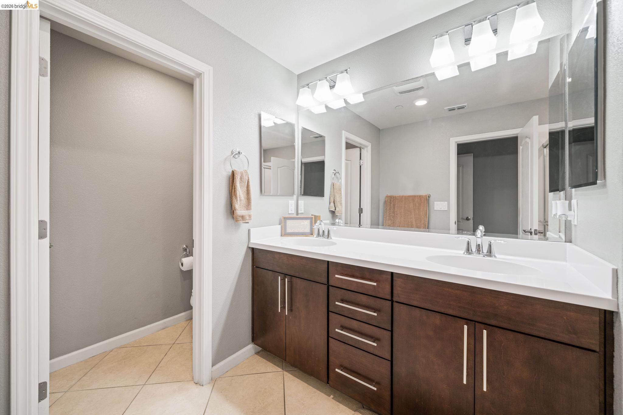 1280 Gusty Loop, Unit 4 Livermore, CA 94550 - Photo 17 of 40 a bathroom with a double vanity sink and a mirror