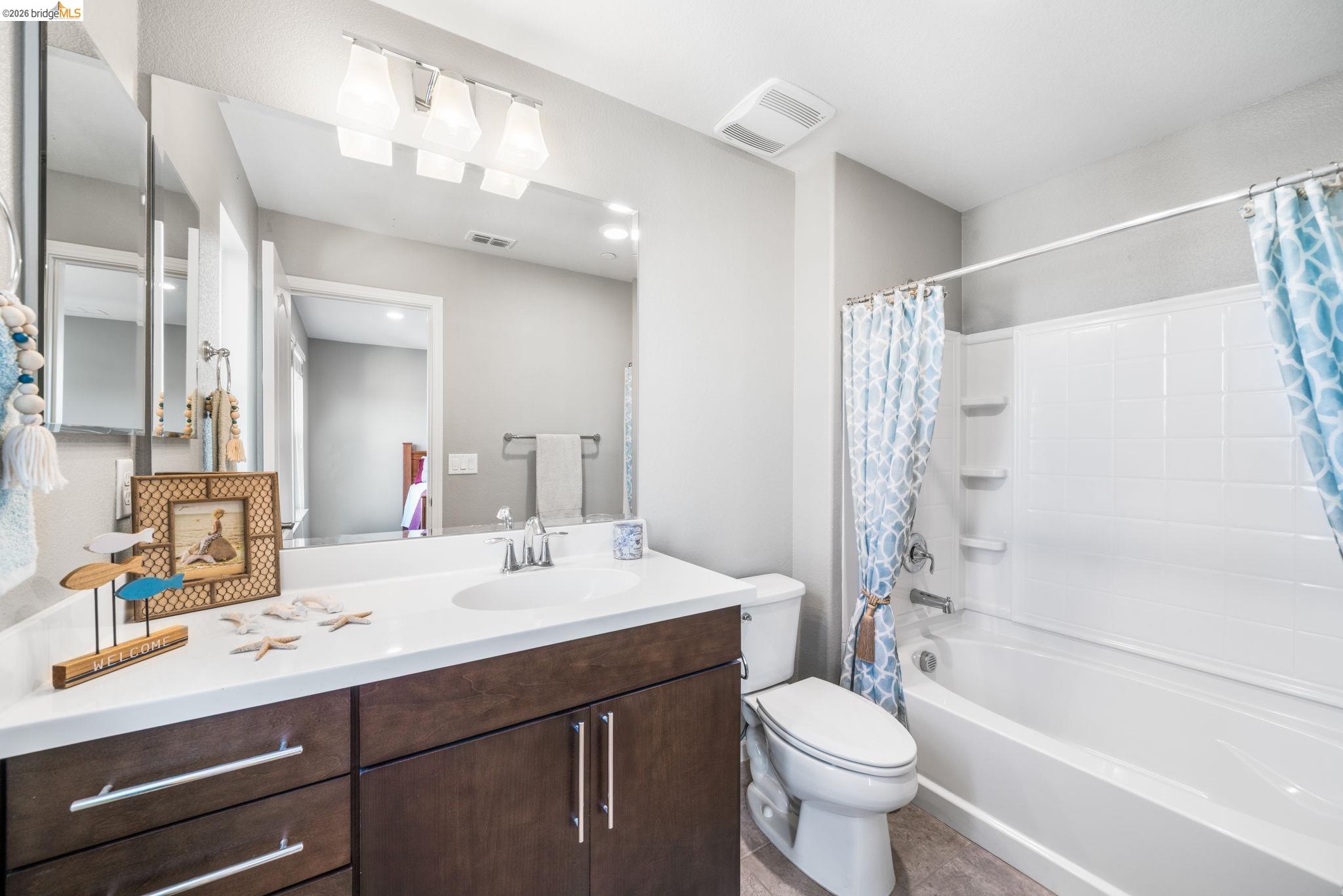 1280 Gusty Loop, Unit 4 Livermore, CA 94550 - Photo 19 of 40 a bathroom with a double vanity sink toilet mirror and shower