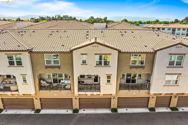 an aerial view of a city with lots of residential buildings and mountain view in back