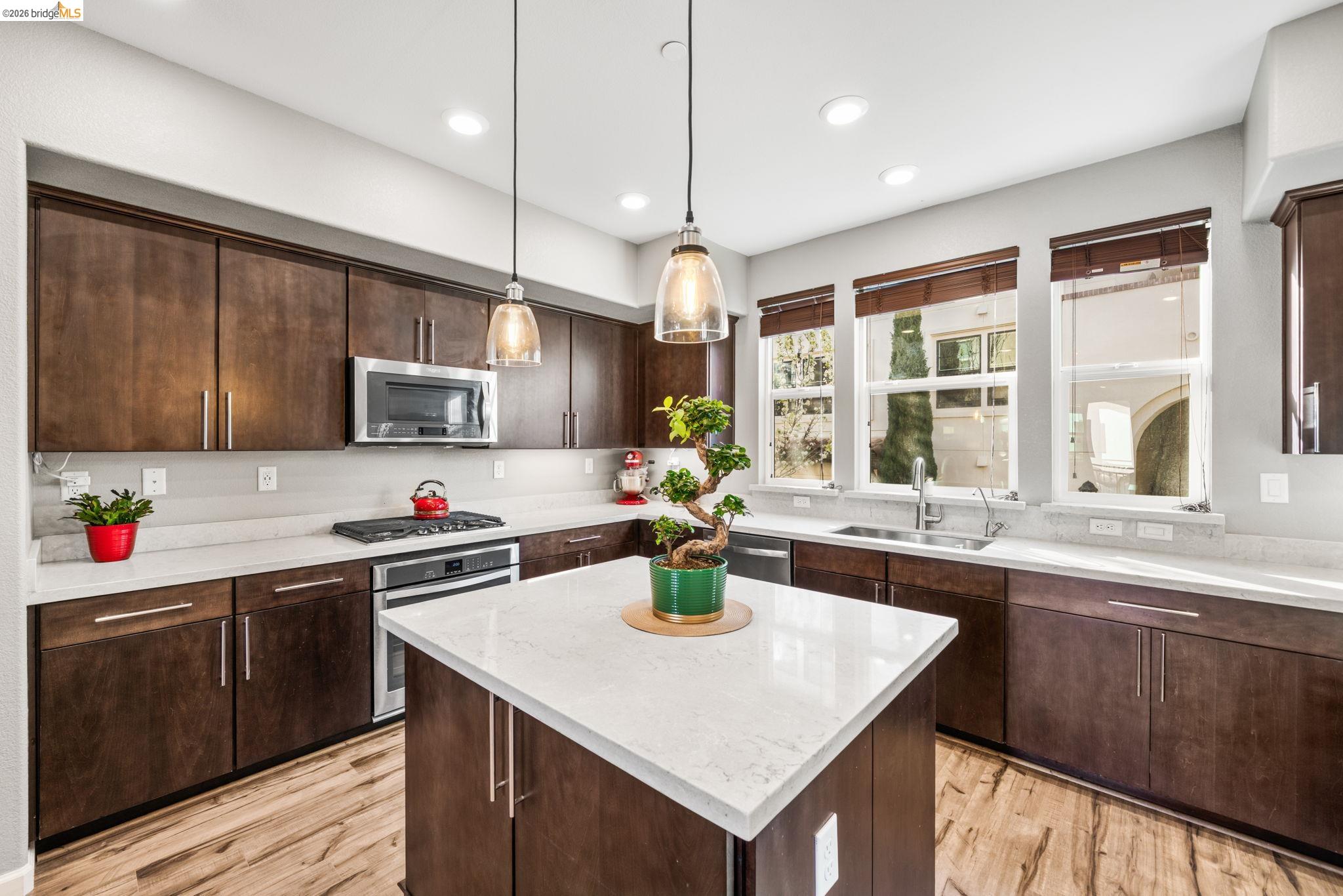1280 Gusty Loop, Unit 4 Livermore, CA 94550 - Photo 4 of 40 a kitchen with stainless steel appliances granite countertop a sink a stove and center island