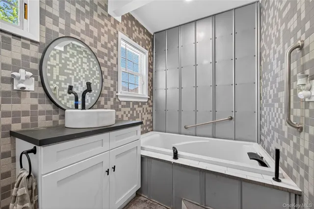 a bathroom with a sink a mirror and a bathtub