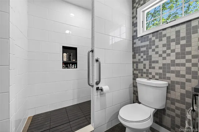 a white toilet sitting next to a shower