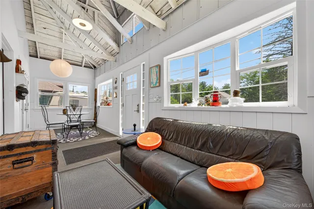 a living room with furniture a flat screen tv and a large window