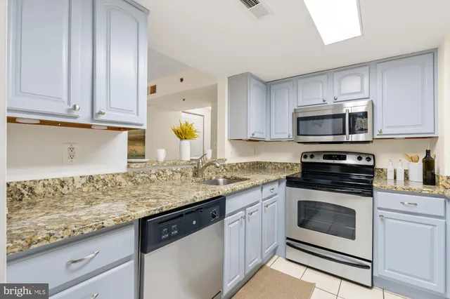 a kitchen with granite countertop cabinets stainless steel appliances and a counter space