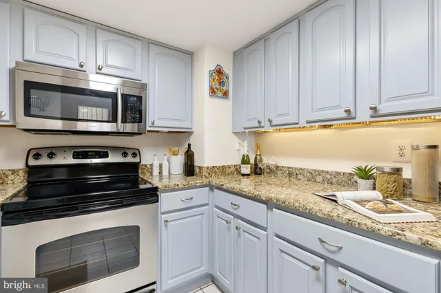 a kitchen with granite countertop a sink a stove and a wooden floors