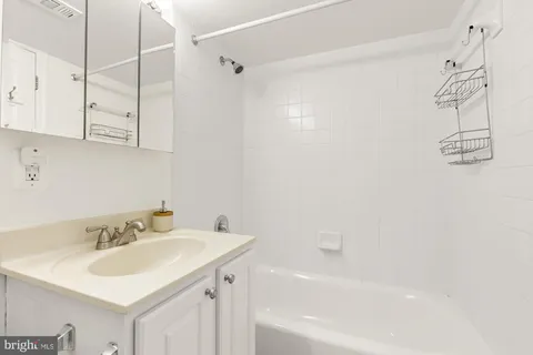 a white bed sitting in a room with a table and a couch