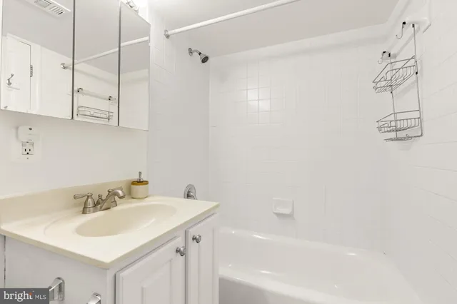 a white bed sitting in a room with a table and a couch