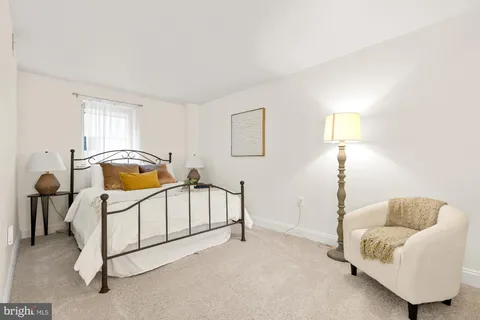 a bedroom with a bed a mirror and lamp