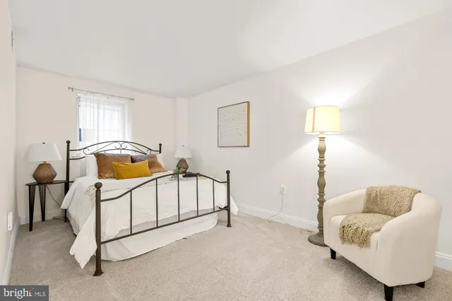 a bedroom with a bed a mirror and lamp