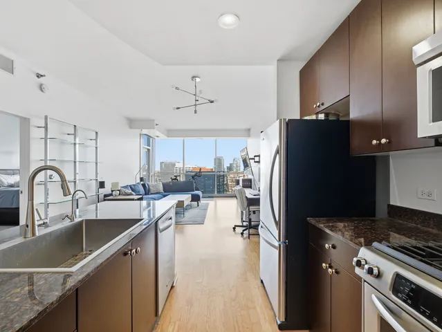 a kitchen with refrigerator a sink and chairs