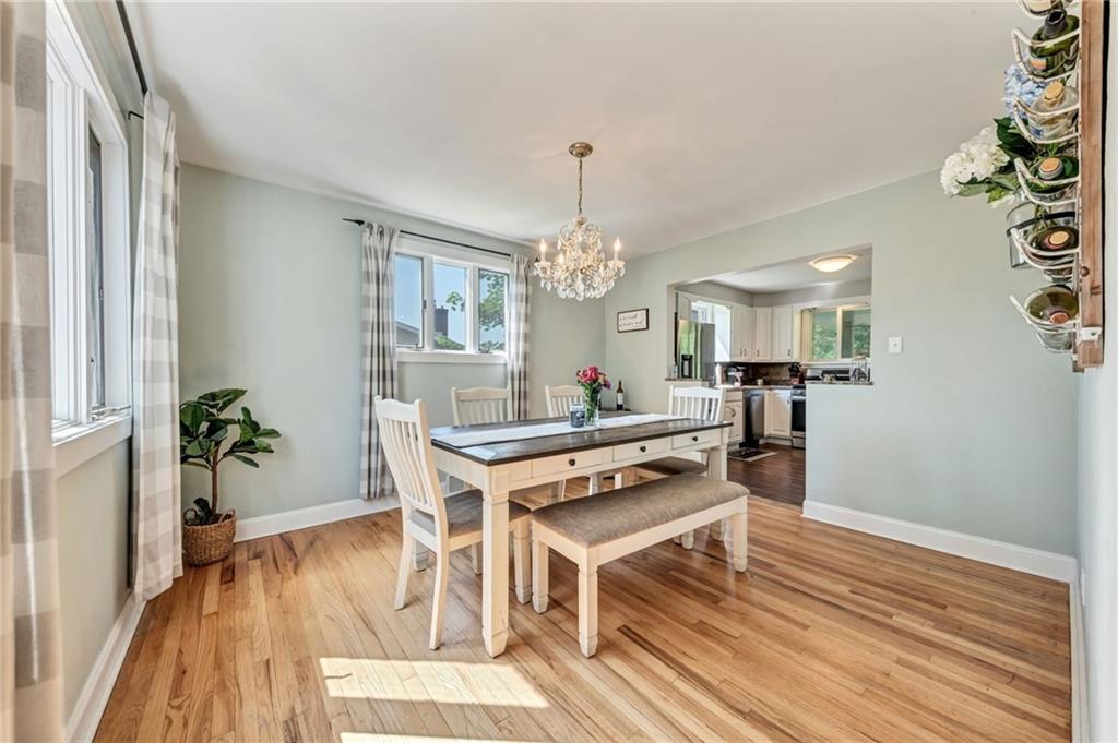 40 Greenview Drive McKees Rocks, PA 15136 - Photo 8 of 42 a dining room with wooden floor a chandelier a wooden table and chairs