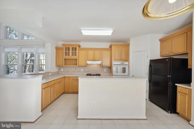 a kitchen with stainless steel appliances granite countertop a refrigerator a stove a sink and a microwave