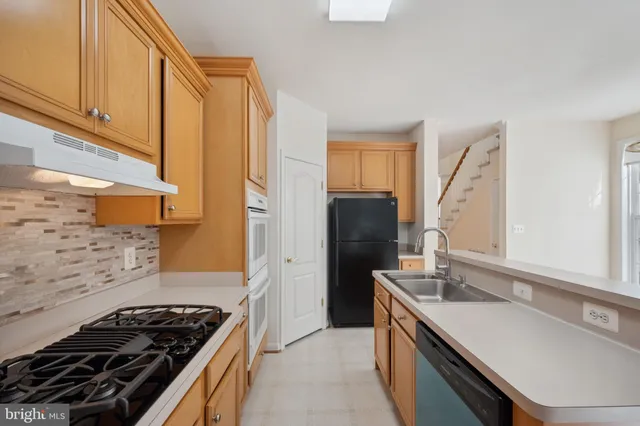 a kitchen with stainless steel appliances a sink stove and refrigerator