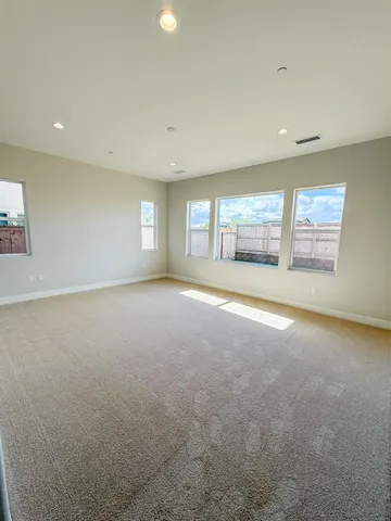 an empty room with a white wall and sitting space
