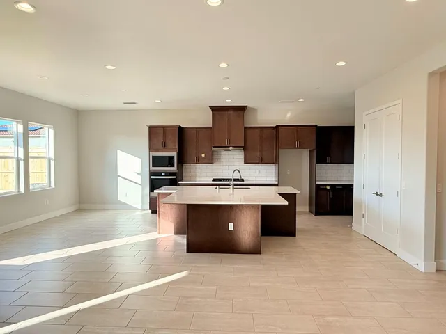 a large kitchen with stainless steel appliances kitchen island a large counter top and a sink