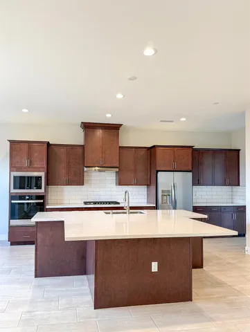 a living room with stainless steel appliances kitchen island granite countertop a couch and a view of kitchen