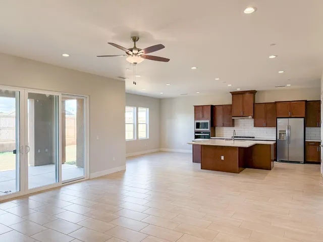 a large kitchen with stainless steel appliances granite countertop a refrigerator a sink a stove a microwave and island