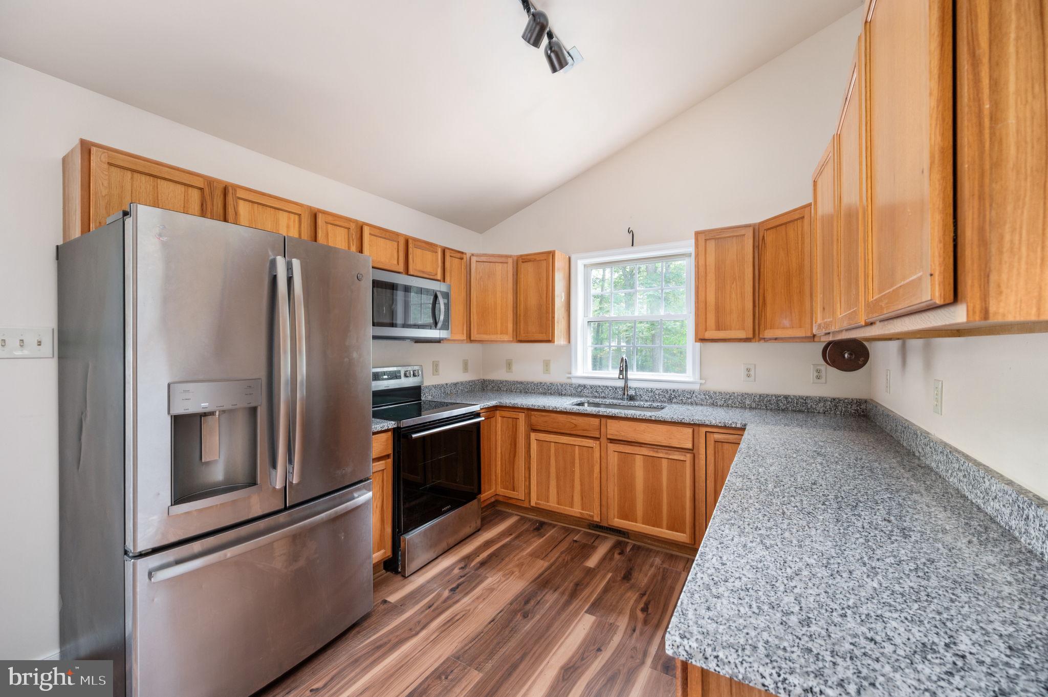 1822 Copper Line Road Bumpass, VA 23024 - Photo 22 of 65 a kitchen with stainless steel appliances granite countertop a refrigerator sink and stove