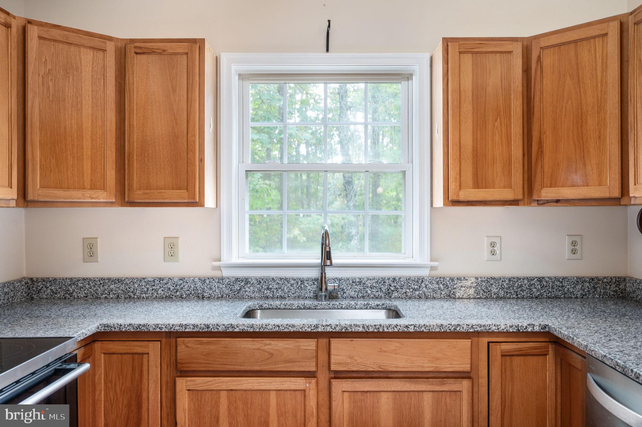 1822 Copper Line Road Bumpass, VA 23024 - Photo 23 of 65 a kitchen with granite countertop a sink window and cabinets