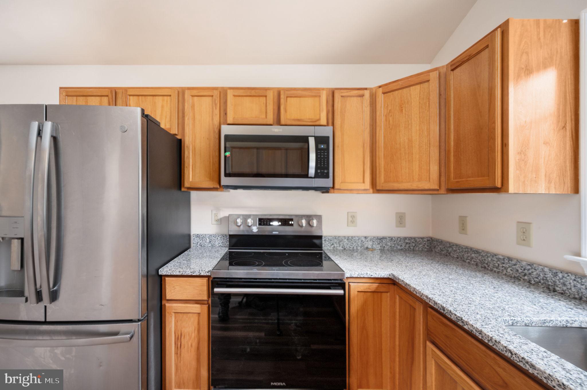 1822 Copper Line Road Bumpass, VA 23024 - Photo 24 of 65 a kitchen with stainless steel appliances granite countertop a refrigerator stove and microwave