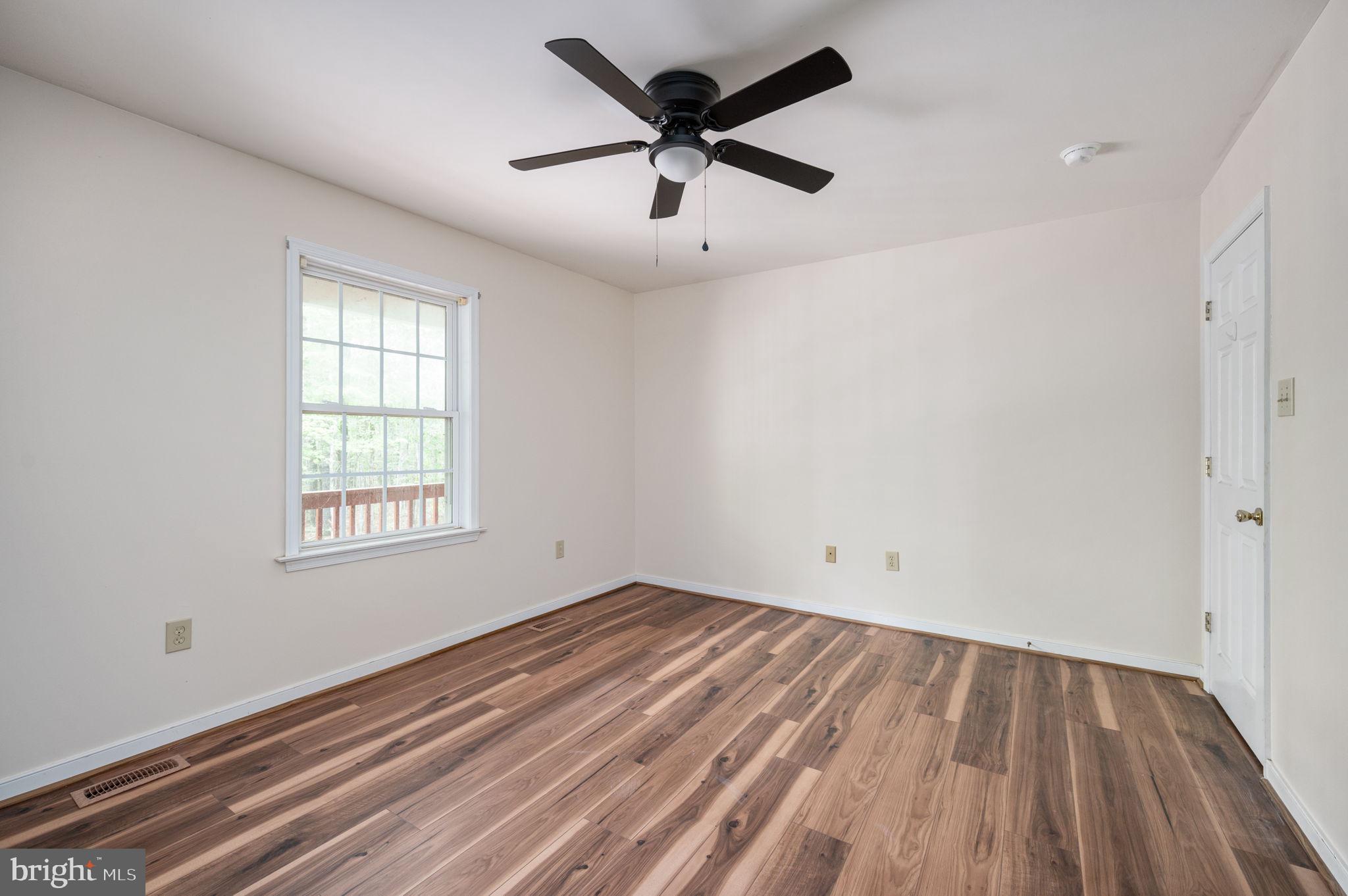 1822 Copper Line Road Bumpass, VA 23024 - Photo 31 of 65 wooden floor in an empty room with a window