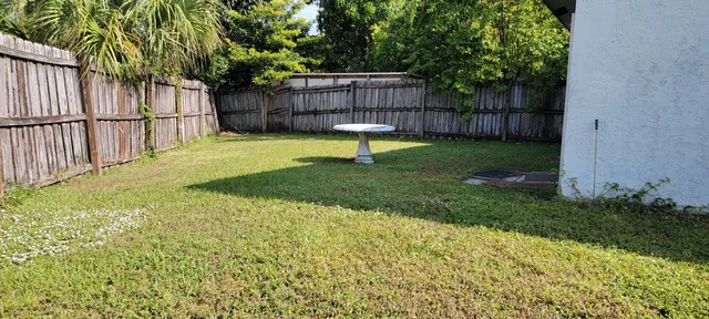 a view of a backyard with a small cabin and wooden fence