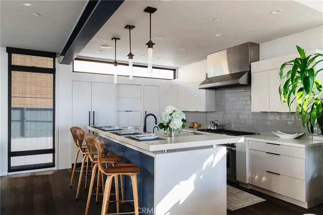a kitchen with stainless steel appliances a sink a counter top space cabinets and a potted plant