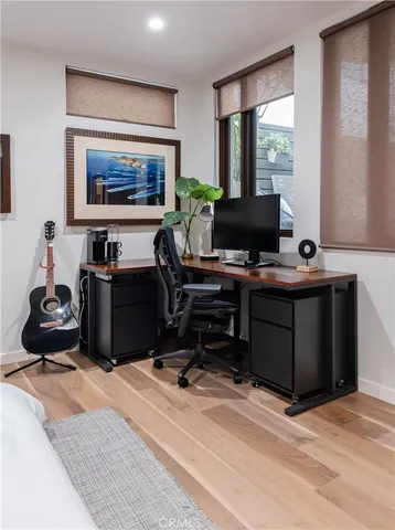 a bedroom with a bed a mirror on dresser and a window