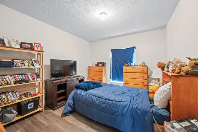 a bedroom with bed and wooden floor