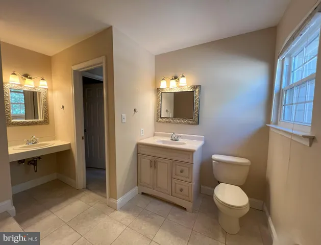 a bathroom with a toilet sink and mirror