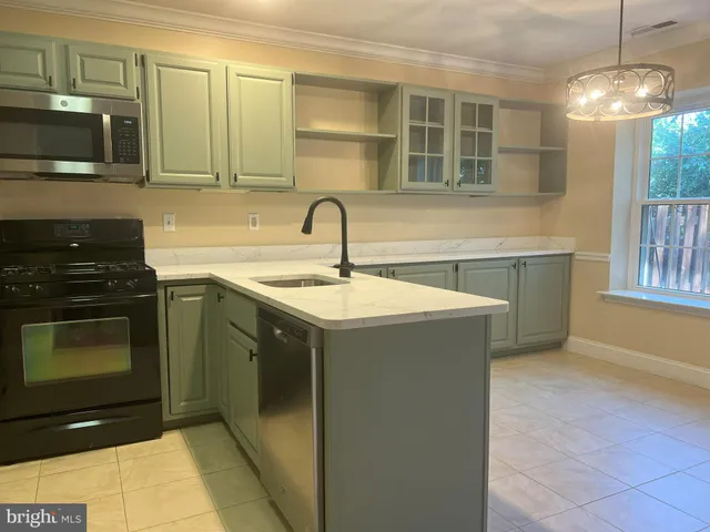 a kitchen with a sink stove and microwave