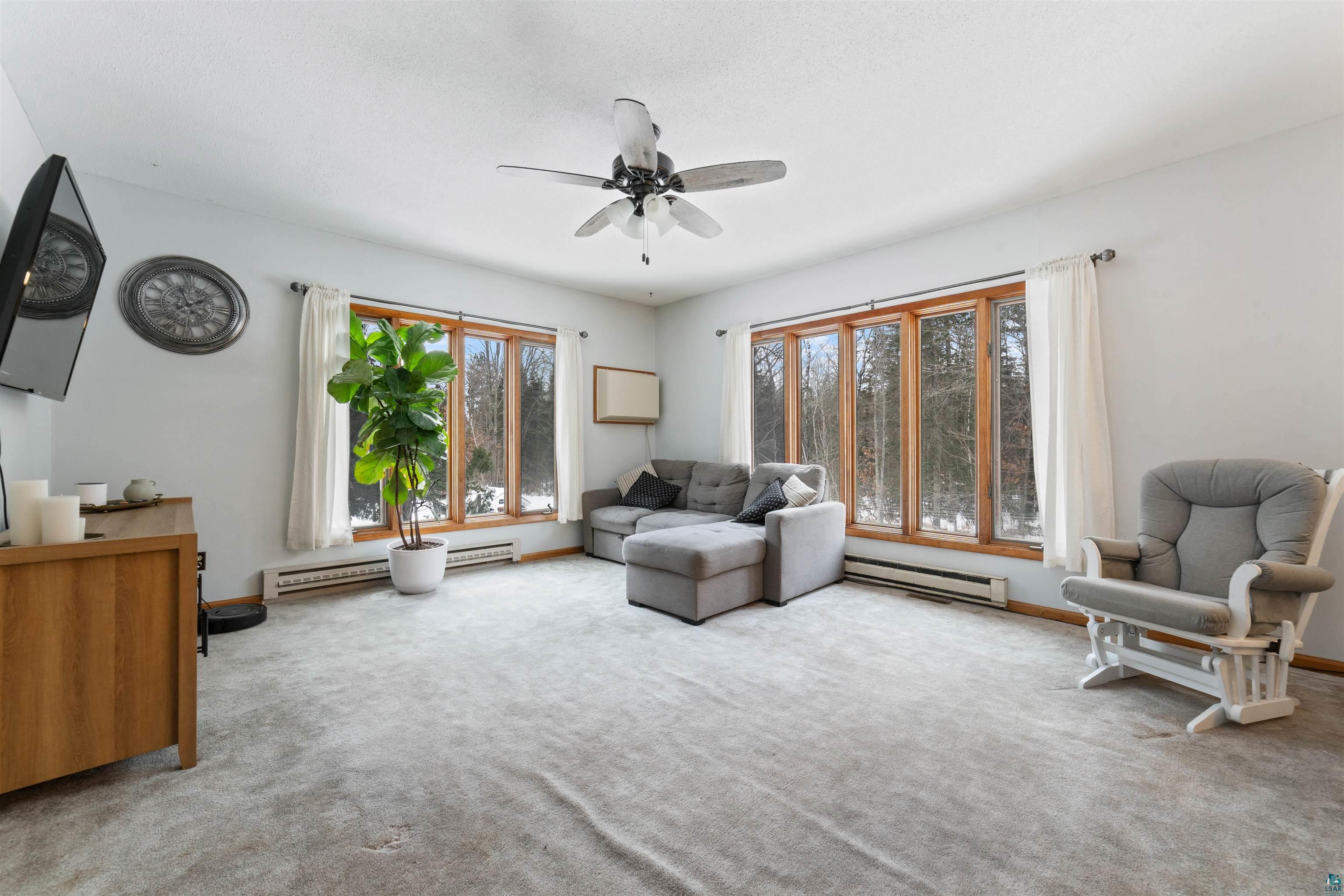 6949 County Rd A Superior, WI 54880 - Photo 3 of 34 Living room featuring ceiling fan, a baseboard radiator, and carpet flooring