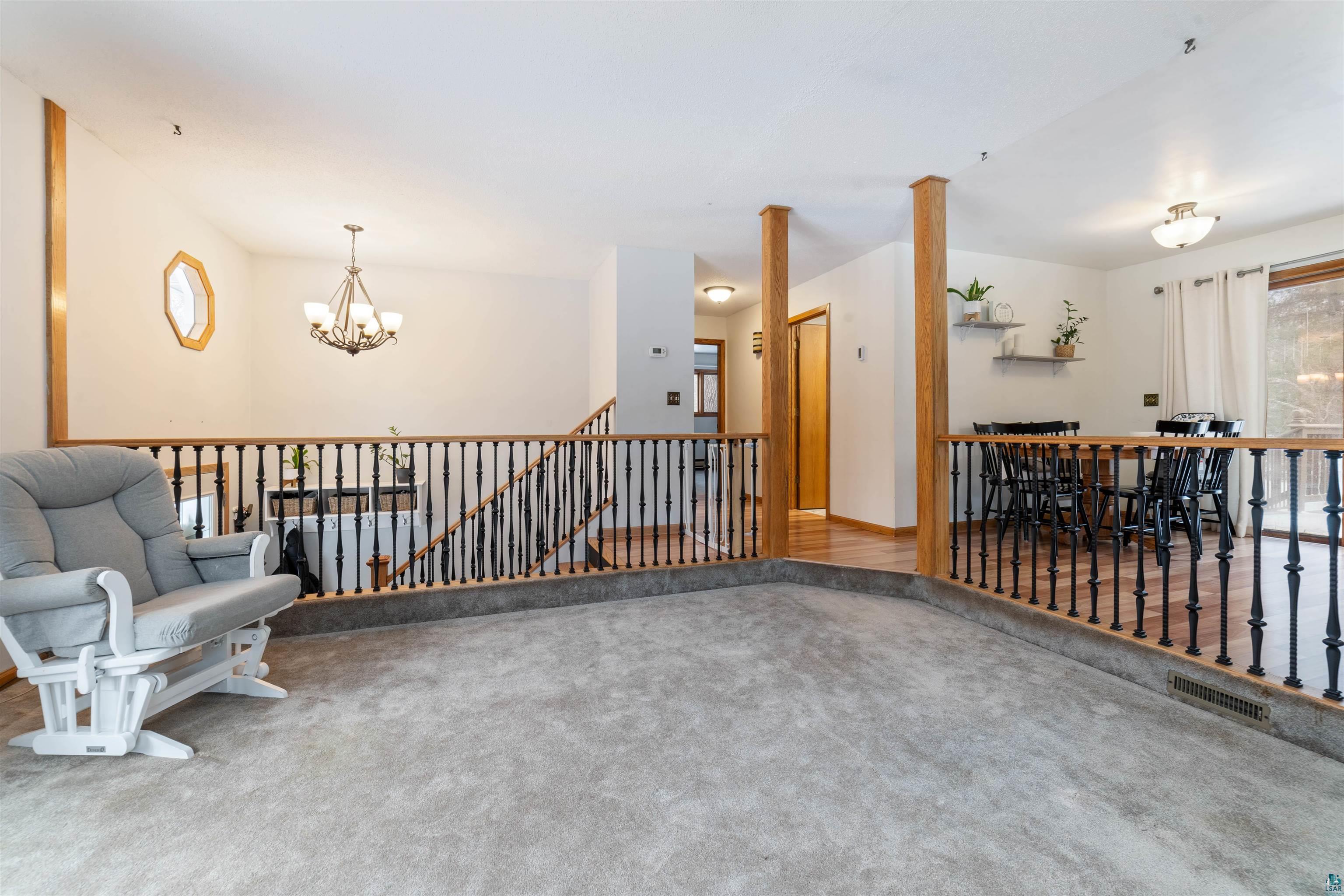 6949 County Rd A Superior, WI 54880 - Photo 5 of 34 Living area featuring an inviting chandelier and carpet floors