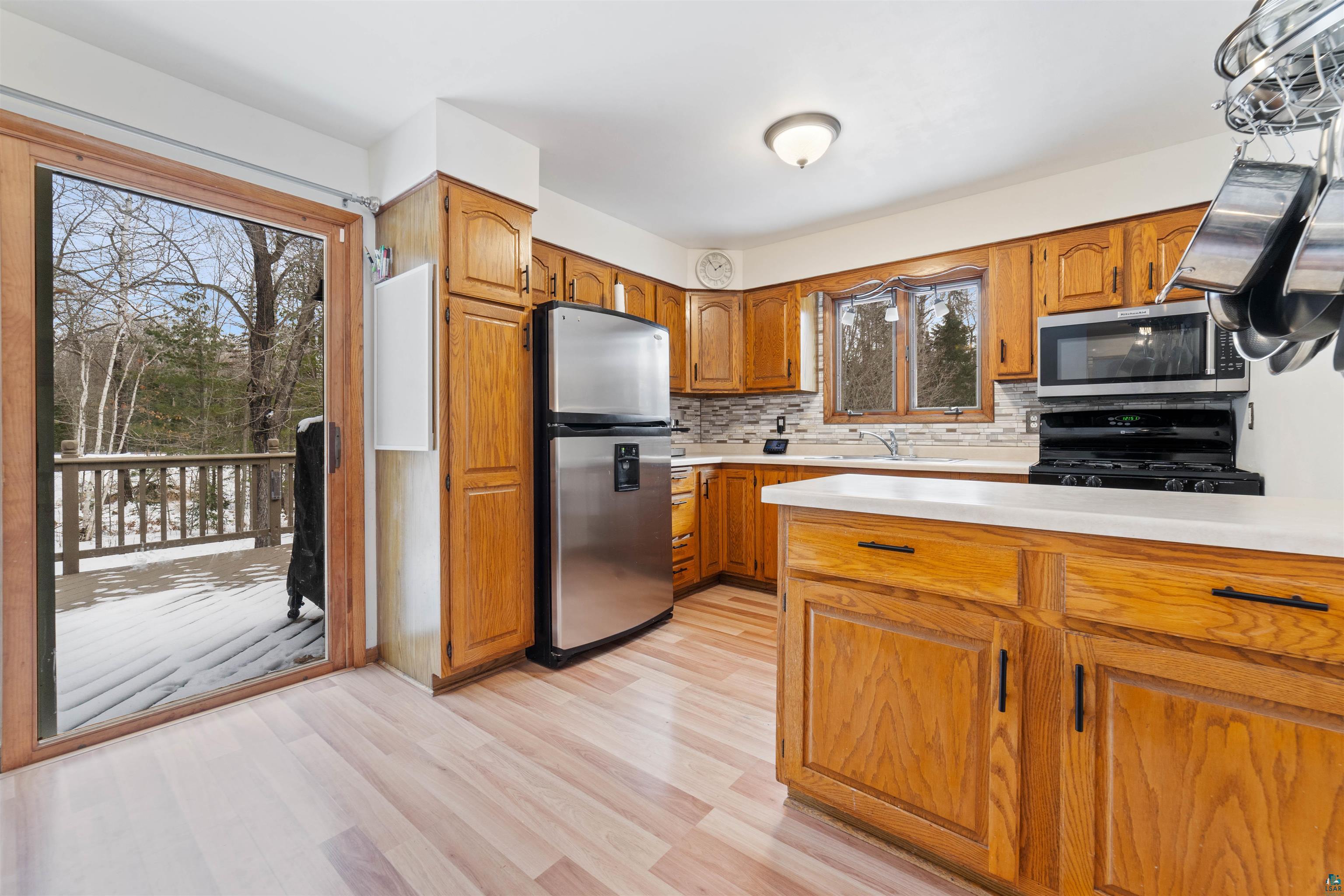 6949 County Rd A Superior, WI 54880 - Photo 6 of 34 Kitchen with light hardwood / wood-style floors, backsplash, stainless steel appliances, and sink