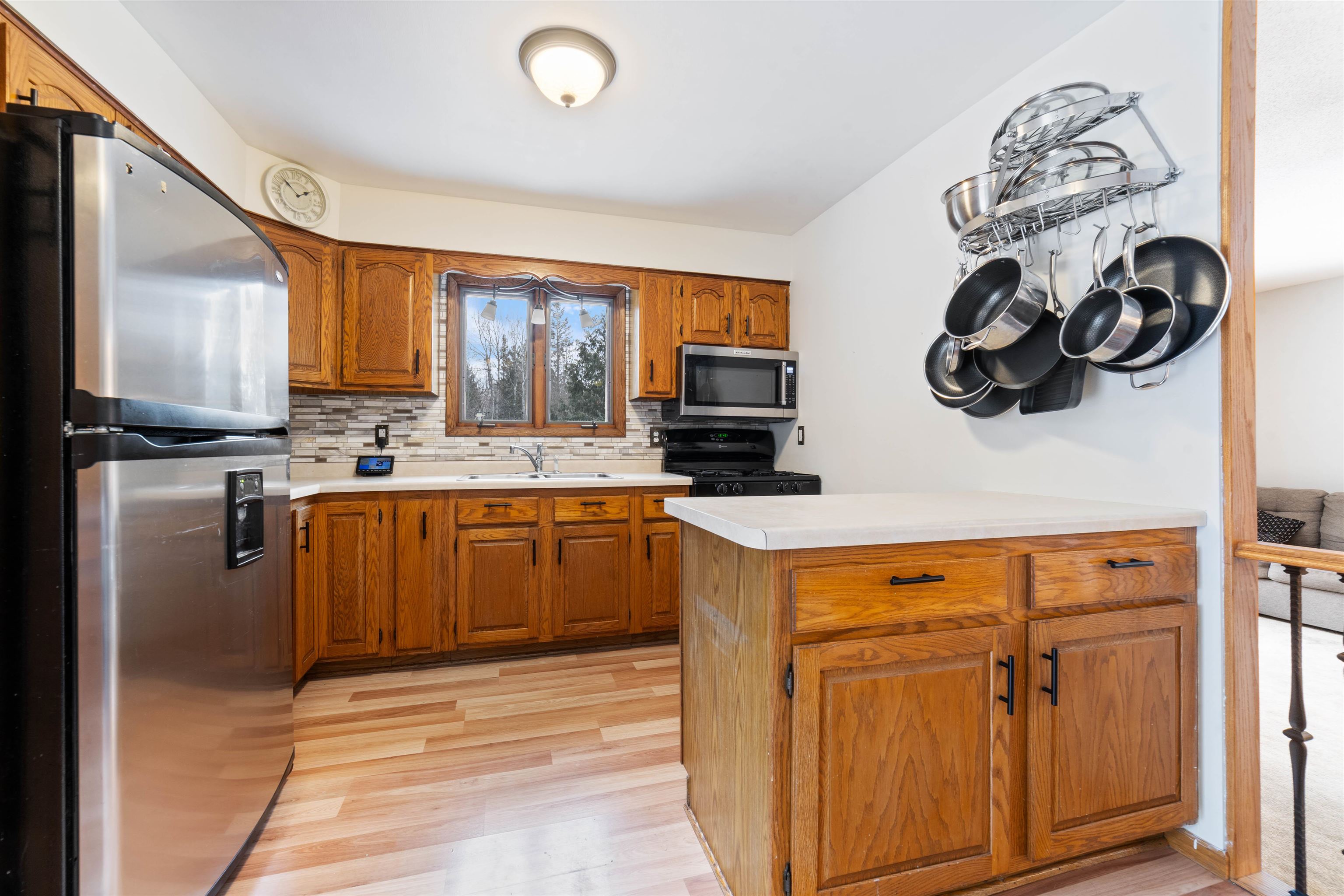6949 County Rd A Superior, WI 54880 - Photo 8 of 34 Kitchen featuring stainless steel appliances, tasteful backsplash, sink, and light hardwood / wood-style flooring