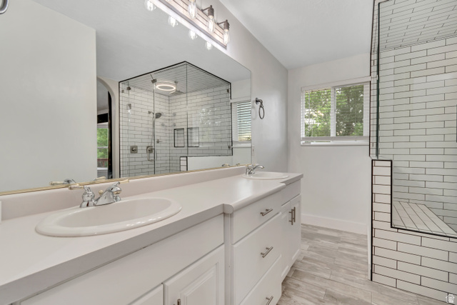 2154 Wasatch Boulevard Sandy, UT 84092 - Photo 15 of 55 Bathroom featuring a stall shower, double vanity, and light wood-style flooring