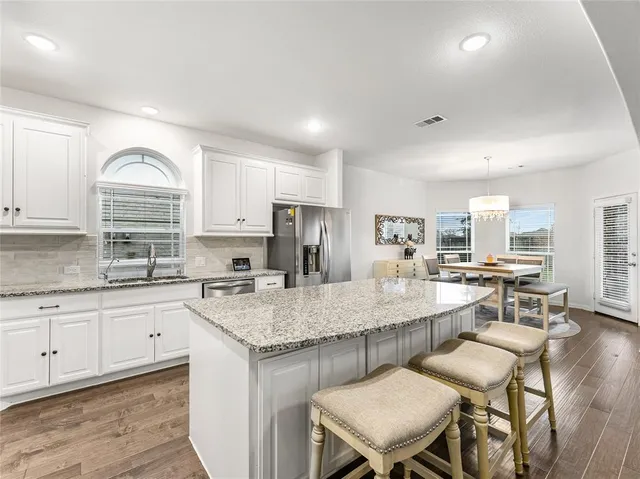 a kitchen with center island table and chairs