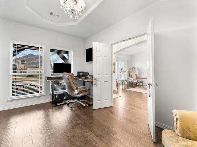 a view of a dining room with furniture a chandelier and wooden floor